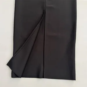 Close-up detail showing the hemline and back slit on a black bandage bodycon evening dress.