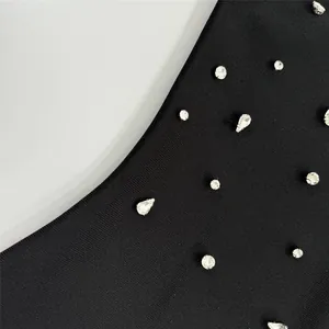 Détail en gros plan montrant des ornements en strass étincelants sur un tissu de robe bandage