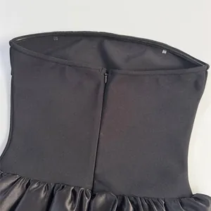 Close-up of the back invisible zipper and bandage fabric detail on the black strapless dress