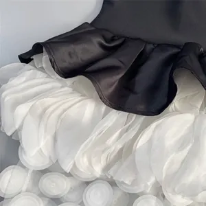 Close-up of the elegant contrast color satin and petal-layered tulle skirt detail