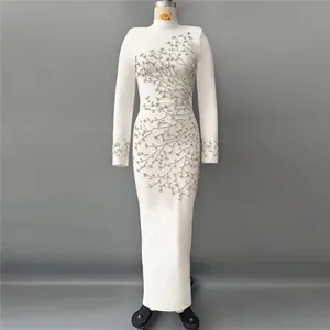 Close-up detail of the intricate silver rhinestone branch pattern on a white bandage dress