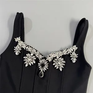 Detailed view of a black bandage dress neckline with sparkling floral crystal embellishments.