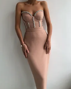 Elegant nude strapless bandage dress with luxury crystal embellishments on corset bodice.