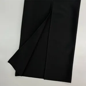Detail view of a high slit on a black bandage evening dress with ribbed texture.