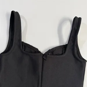 Detail view of the neckline and zipper on a black bandage mini dress with straps.
