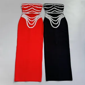 Detailed view of red and black strapless bandage dresses featuring sparkling rhinestone rows.