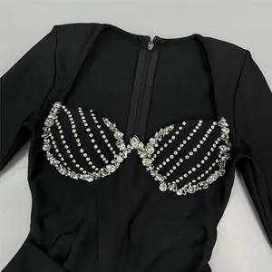 Close-up detail of luxury black long sleeve bandage dress with heavy rhinestone bust