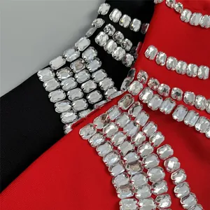 Close-up detail of shimmering rhinestones on elegant red and black bandage dress fabric