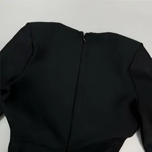 Macro close-up detail of a premium black bandage dress showing the hidden back zipper area