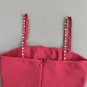 Detail showing elegant pearl and rhinestone straps on a bright pink bandage party dress