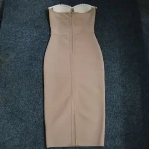 Detailed back view of a beige strapless bandage midi dress featuring rhinestone trim and zipper