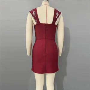 Achteraanzicht van een bordeauxrode bandagejurk met strassdetails op een paspop in de winkel