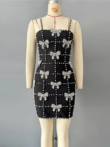Elegant black bandage evening dress with spaghetti straps and white beaded bow motifs