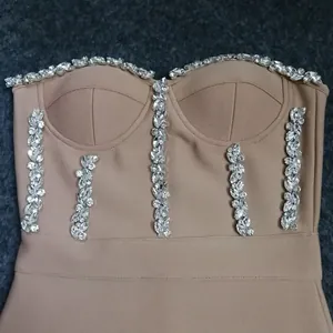 Close-up of nude bandage dress with sparkling rhinestone embellishments on bodice