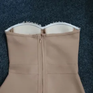 Detailed view of back zipper and sparkling crystal trim on a nude strapless bandage dress