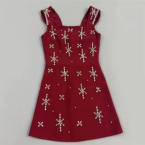 Detailweergave van een elegante bordeauxrode bandagejurk met sprankelende strass-details