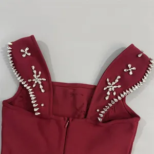 Detailweergave van een bordeauxrode bandagejurk met verfijnde fonkelende straspatronen.
