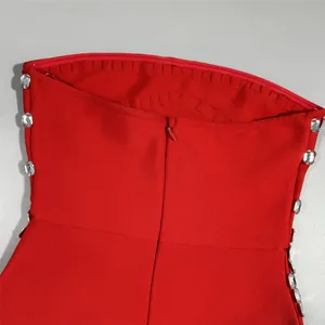 Close-up view of red strapless bandage dress with rhinestone accents and back zipper detail.