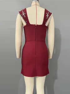 Elegante bordeauxrode bandagejurk met luxe strass op de schouders, achterzijde top.