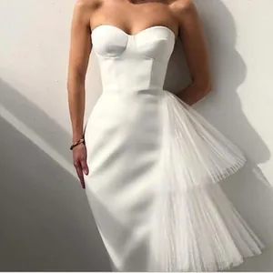 Elegant white strapless bodycon evening gown featuring layered mesh tulle design detail