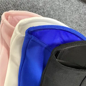 Close-up of layered mesh and bandage fabric texture in pink, white, blue, and black colors.