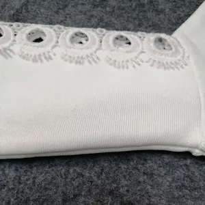 Detail of white bandage fabric featuring elegant circular embroidery lace trim.