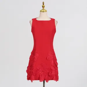 Detailed view of an elegant red sleeveless dress with 3D floral appliques at the hem