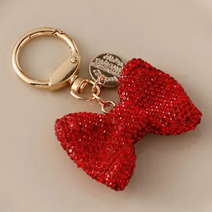 Sparkling red rhinestone bow keychain with golden lobster clasp for elegant bag charms