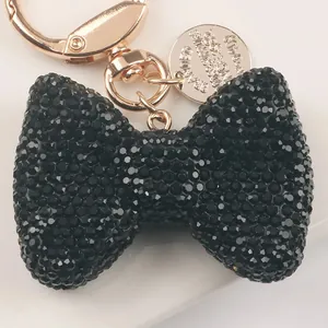 Close-up of a sparkling black rhinestone bow keychain with rose gold hardware.