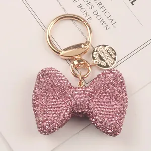 Macro view of pink rhinestone bow keychain with elegant gold-tone clasp detail