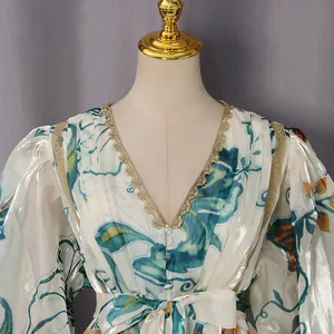 Detail view of a V-neck floral dress featuring delicate gold lace trim and puff sleeves.
