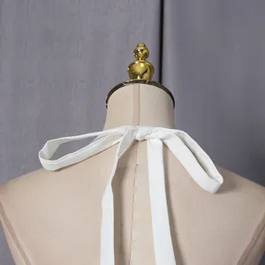 Detailopname van de elegante witte halterstrik op een lange jurk in Franse stijl