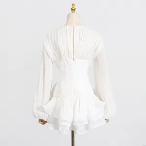 Achteraanzicht van een witte Franse mini-jurk met ruches en elegante pofmouwen