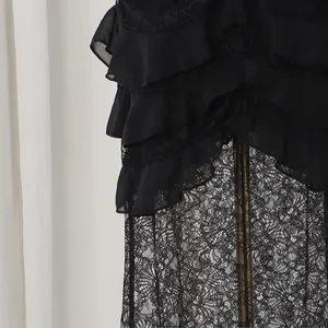 Close-up detail of the intricate black floral lace and ruffled tiers of the evening dress