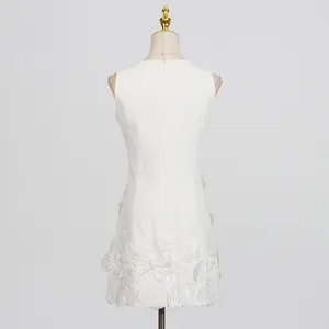 Back view of elegant white sleeveless dress with detailed 3D floral hem embroidery