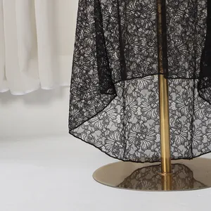 Detailed view of intricate black floral lace pattern on an elegant evening dress hem
