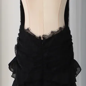 Detailed view of black lace halter dress back with eyelash lace trim and ruffled layers