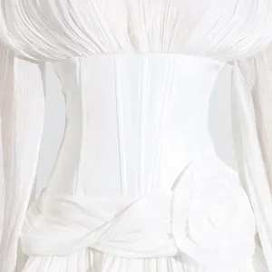Detailopname van witte Franse jurk met een korsettafwerking en een luxe 3D-bloemaccent