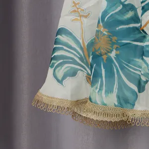 Detail of blue floral print dress hem with decorative gold lace fringe trim