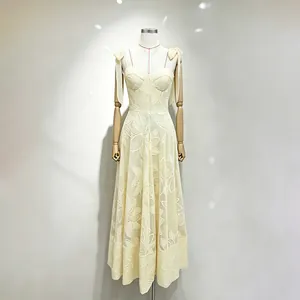 Close-up detail of a sweet yellow embroidered long dress with bow straps on a mannequin.