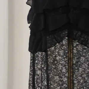 Close-up of intricate black lace and layered ruffle details on an evening dress