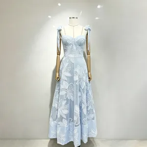 Detailed view of light blue spaghetti strap dress with white floral embroidery.
