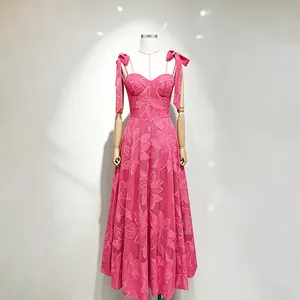 Macro view of bright pink embroidered maxi dress with bow straps and fitted waist.