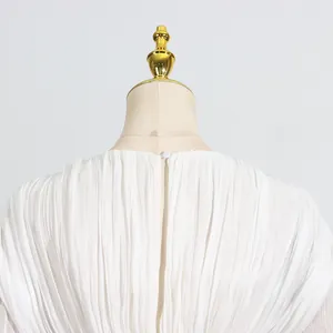 Detailopname van de knoopsluiting en de fijne plisséstof van een elegante witte jurk