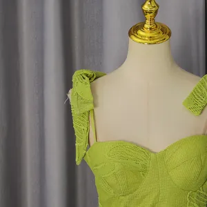Close-up of lime green embroidered lace dress with bow straps and sweetheart neckline.
