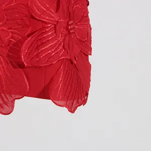 Macro detail of the elegant 3D floral embroidery and red pearl beads on this mini dress