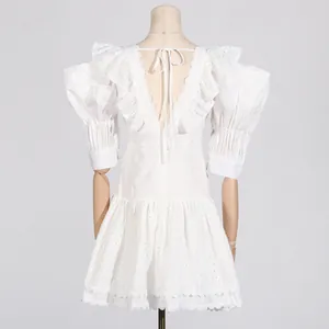Back view of white French style mini dress with puff sleeves and lace embroidery detail