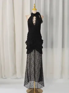 Black lace halter deep V-neck evening dress with ruffled fishtail skirt and flower detail.
