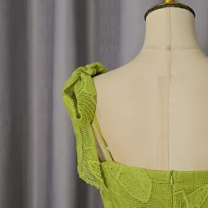Detailed close-up of lime green embroidered lace dress with delicate shoulder strap