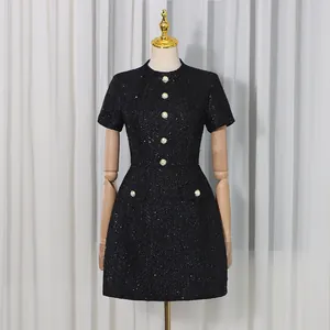 Robe élégante en tweed noir de style Chanel avec boutons nacrés et chic à la française.